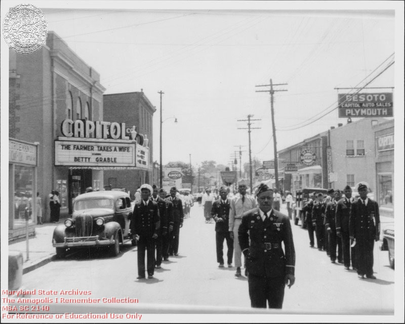 1953 Unknown West Street near Southgate, black servicemen in parade marching past Capitol Theater, possibly veterans